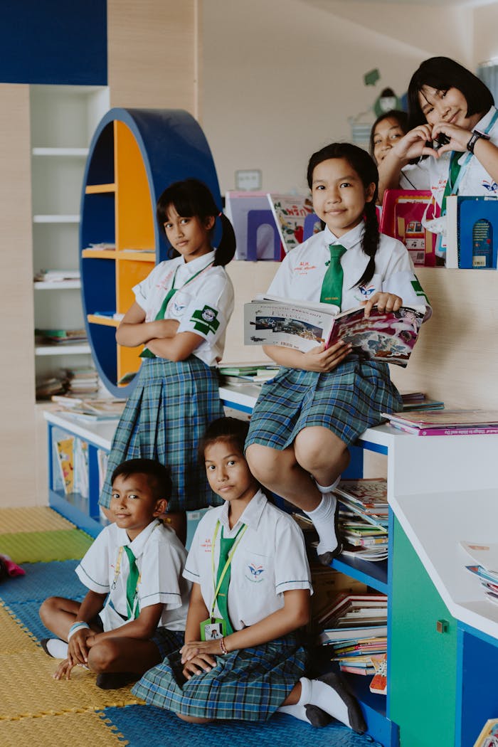 School children in uniforms reading together in a library setting.
